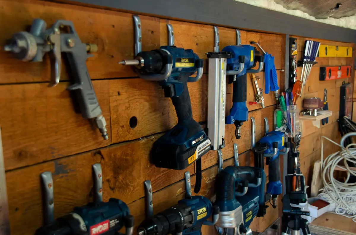 Des outils rangés avec soin sur un mur en bois.
